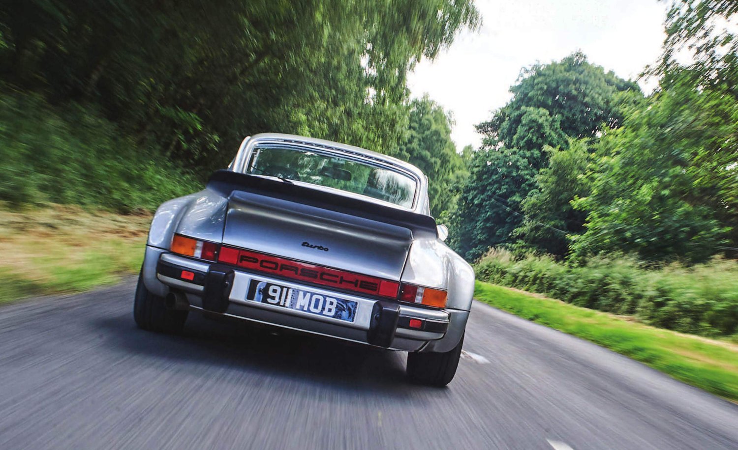 A Porsche driving down a road.