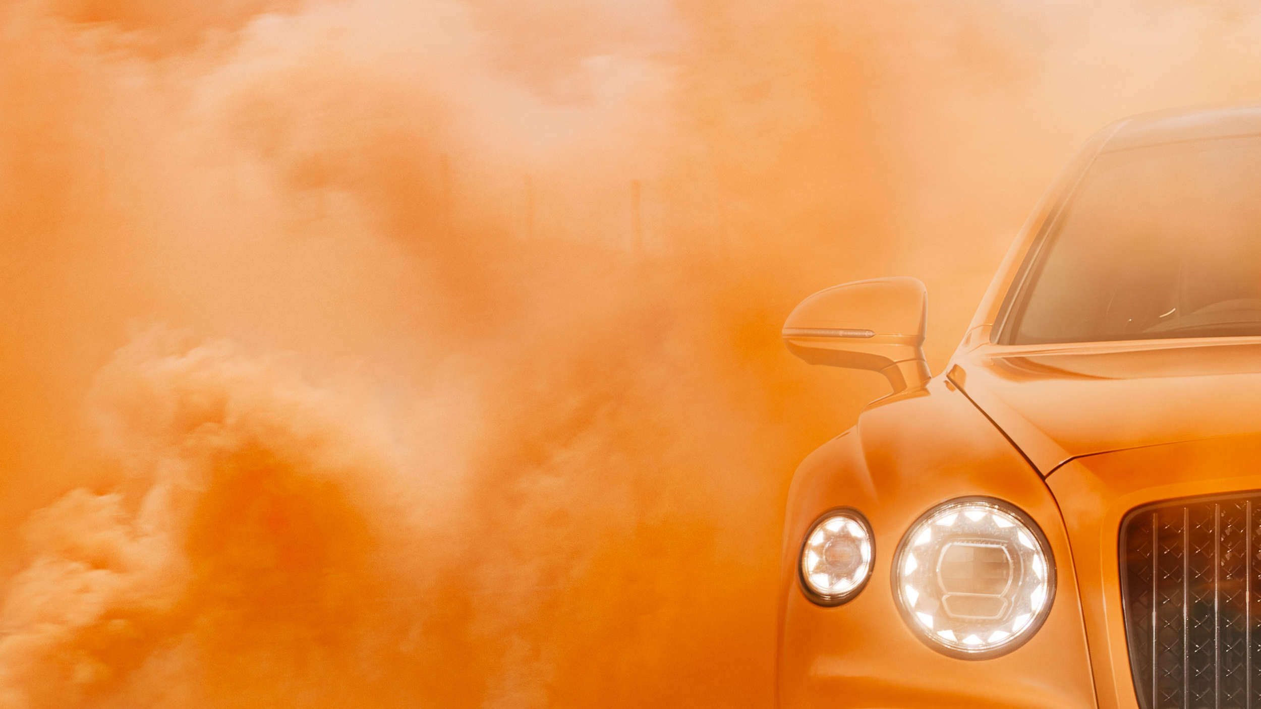 Bentley motor car in orange smoke